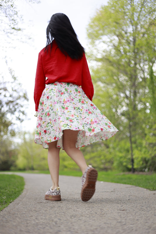 Flower party skirt and a red linen shirt, both designed and produced by ELZi worn by Sanaz. It's like she's going to fall or something... what's this pose ?