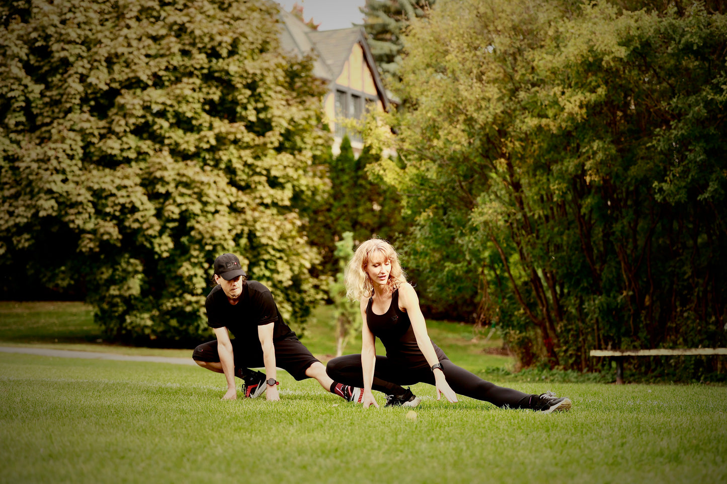 Jonathan Brunelle and Olha in King George Park - City of Westmount doing some stretching and mobility training wearing ELZi activewear. Clothes made by hand in Montreal.