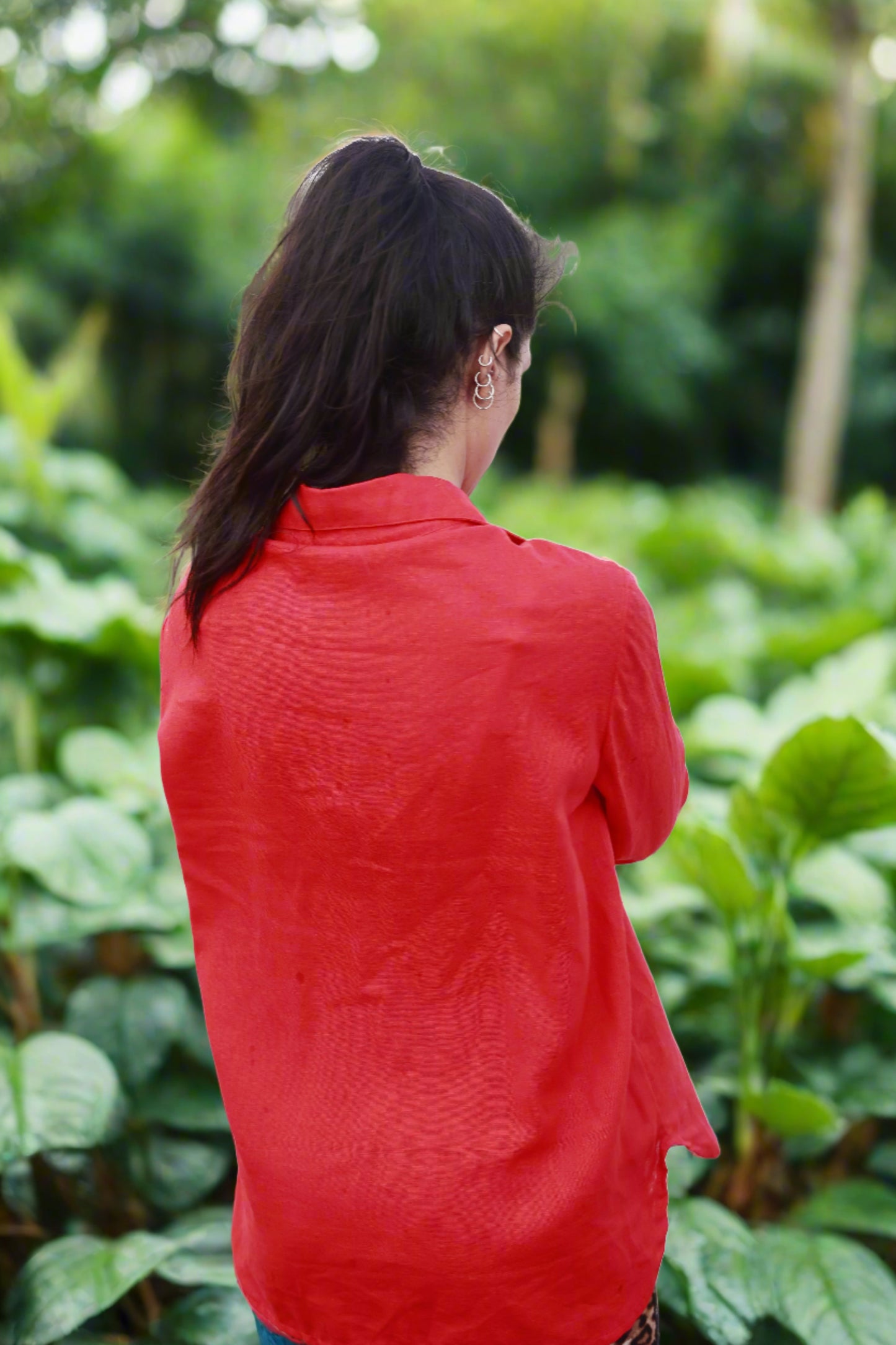 Vue de dos de Sanaz Firouzi qui porte une luxueuse chemise en lin rouge. Fait au Québec. Chemise Lin Rouge par ELZi, Couturière à Verdun. Red Linen Shirt