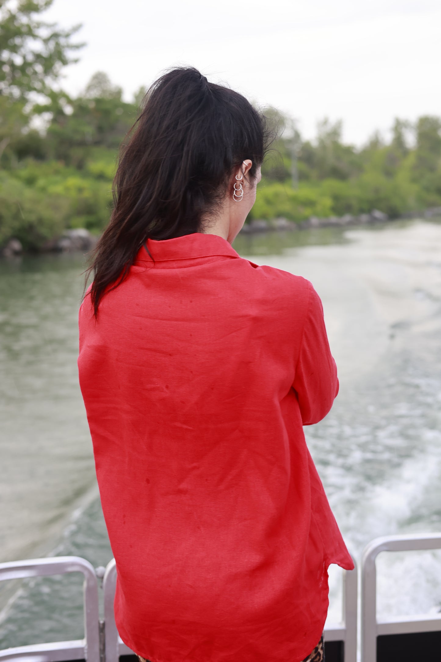 Vue de dos de Sanaz Firouzi qui porte une chemise en lin rouge. Fait au Québec.